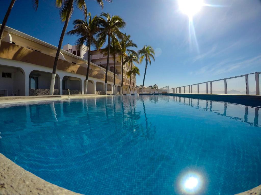 曼萨尼约马贝拉酒店的一座棕榈树大型游泳池和一座建筑