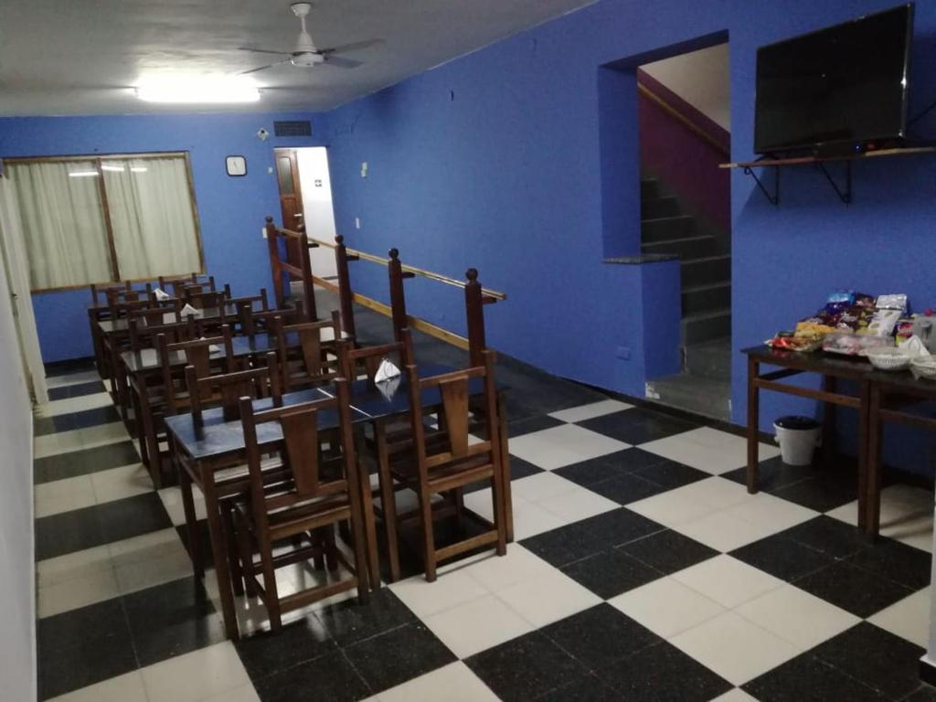 圣罗莎La Nueva Estancia的一间配备有桌椅和蓝色墙壁的餐厅