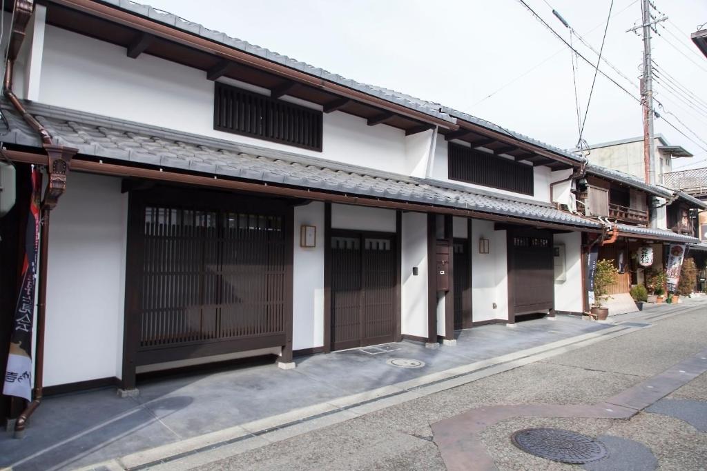 长滨市Machiya no Yado Iroha的街上的白色建筑,有棕色门
