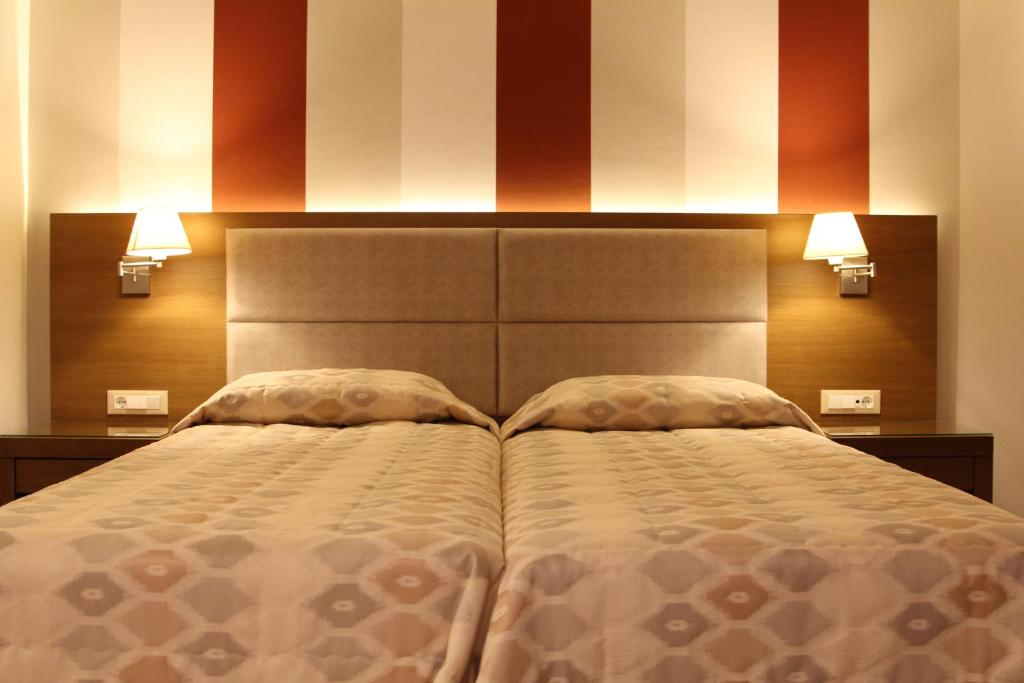 迈索尼阿契尔斯酒店的一间卧室配有一张大床和两个枕头