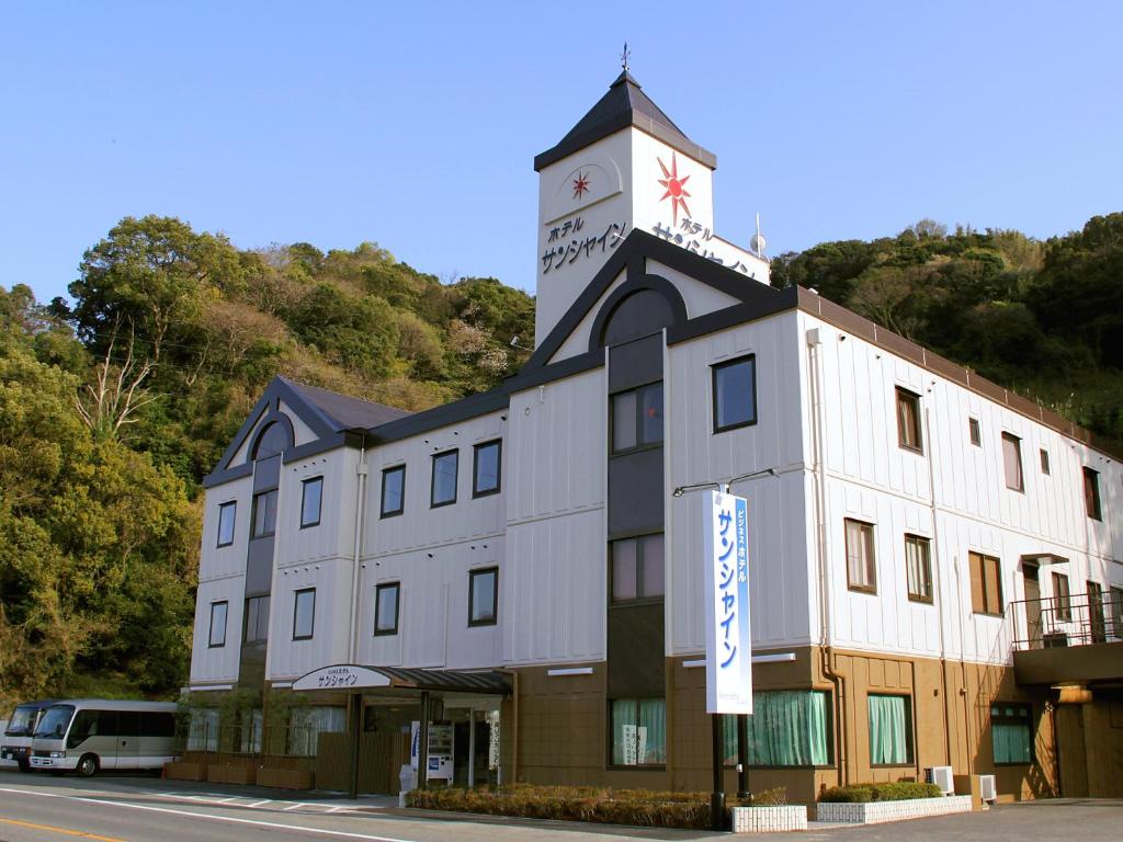 有田田川温泉阳光酒店的一座建筑的顶部有一个钟楼