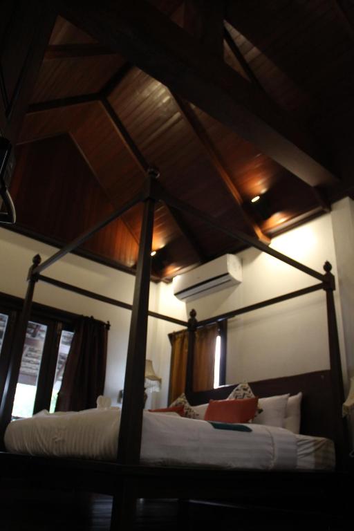琅勃拉邦Alana Luang Prabang的卧室配有带白色床单的天蓬床