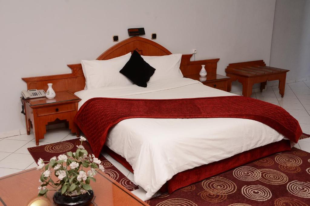 拉巴特Hotel Bouregreg的一间卧室配有一张带白色和红色床单的大床