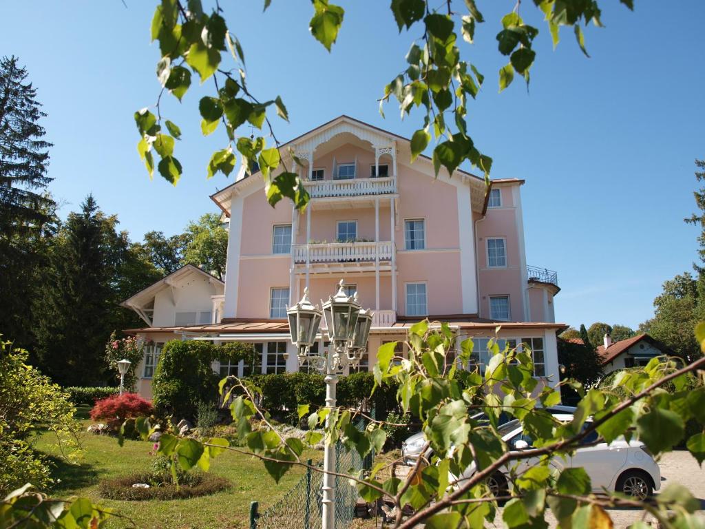 波金格Hotel Villa Sisi的一座带庭院的大型粉红色建筑