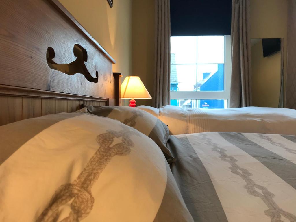 丁格尔Ashes Seafood Restaurant Accommodation的酒店客房设有两张床和长颈鹿床头板
