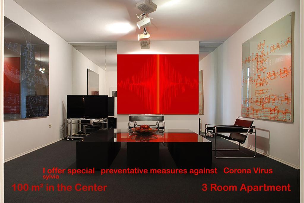 慕尼黑Artist Residence Schwabing的客厅设有红色的墙壁和桌子