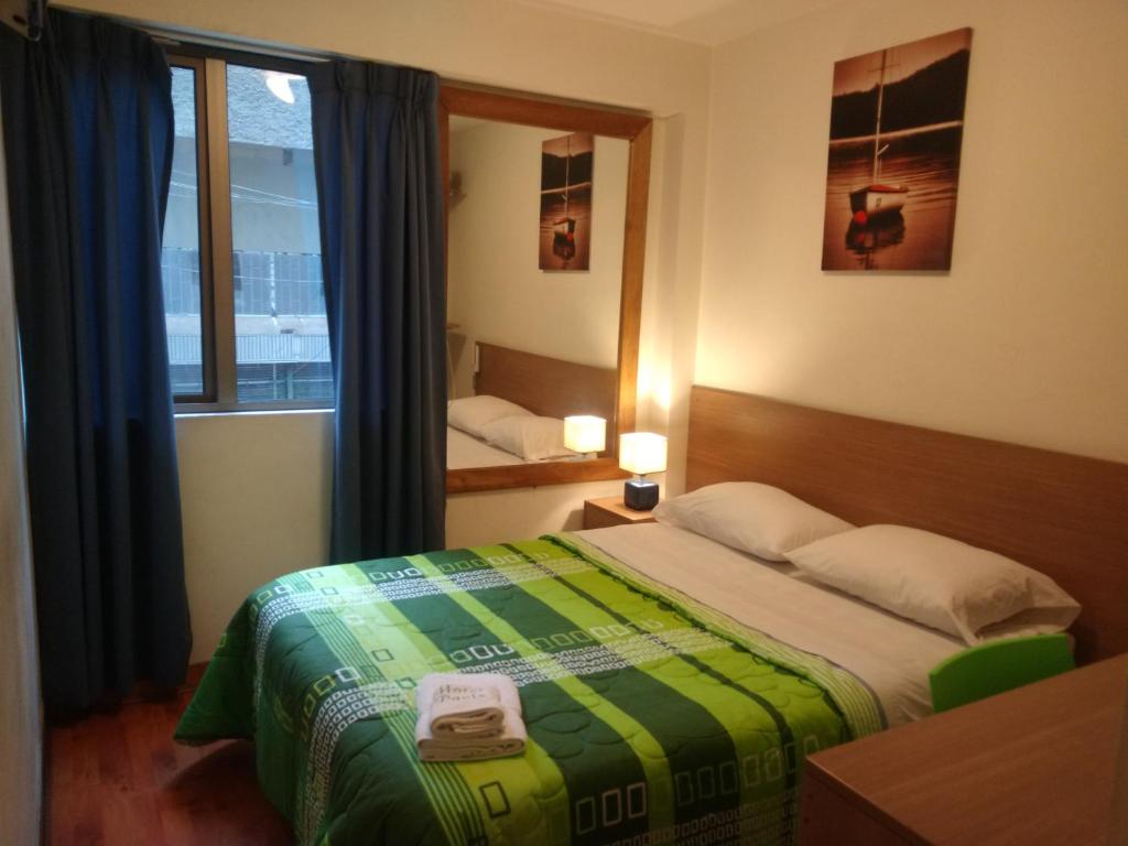 利马利马巴黎酒店的一间小卧室,配有床和窗户