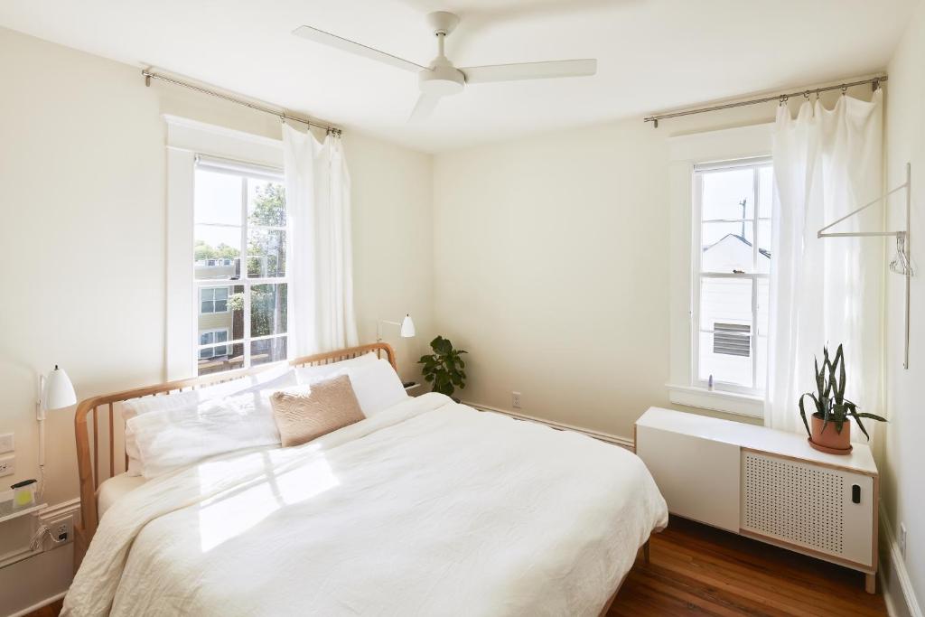 罗利Guest House Raleigh的卧室配有白色的床和2扇窗户。