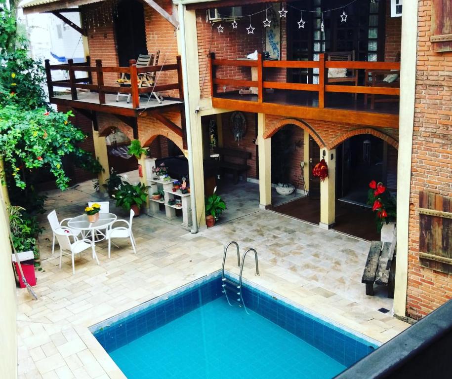 瓜鲁雅Pousada Recanto da Estrela的一个带游泳池和甲板的户外庭院