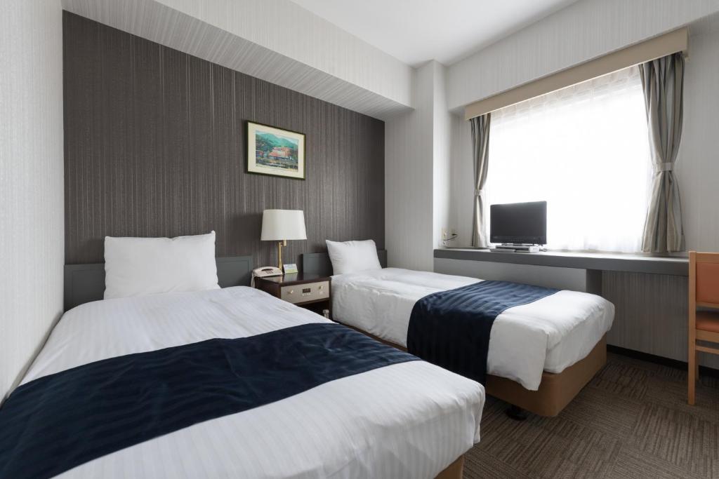 鸟取市鸟取市酒店的一间酒店客房,设有两张床和电视