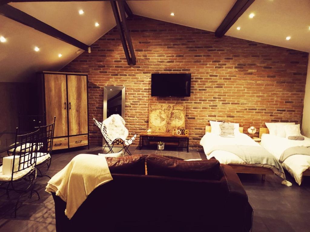 欧奈索斯博伊斯Le Loft的一间卧室设有两张床和砖墙