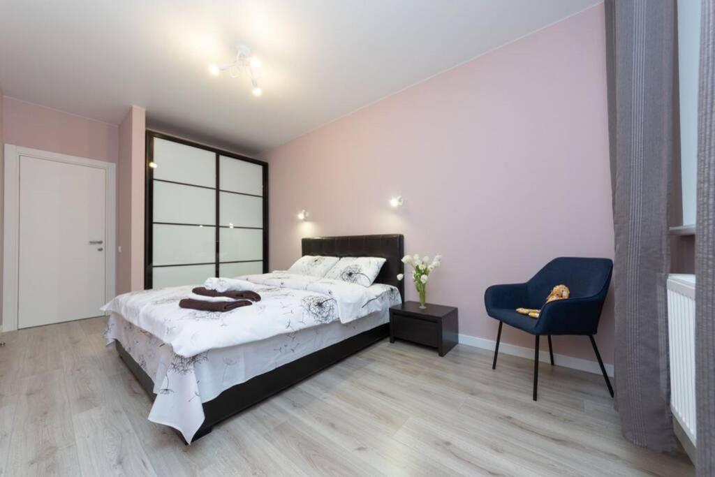 基辅Чудесная 2 комнатная квартира люкс уровня Теремки的一间卧室配有一张大床和一张蓝色椅子