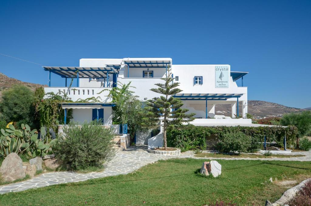 米科利维亚Crystal Naxos 1 Studios at Mikri Vigla的一座白色的大房子,前面设有一个花园
