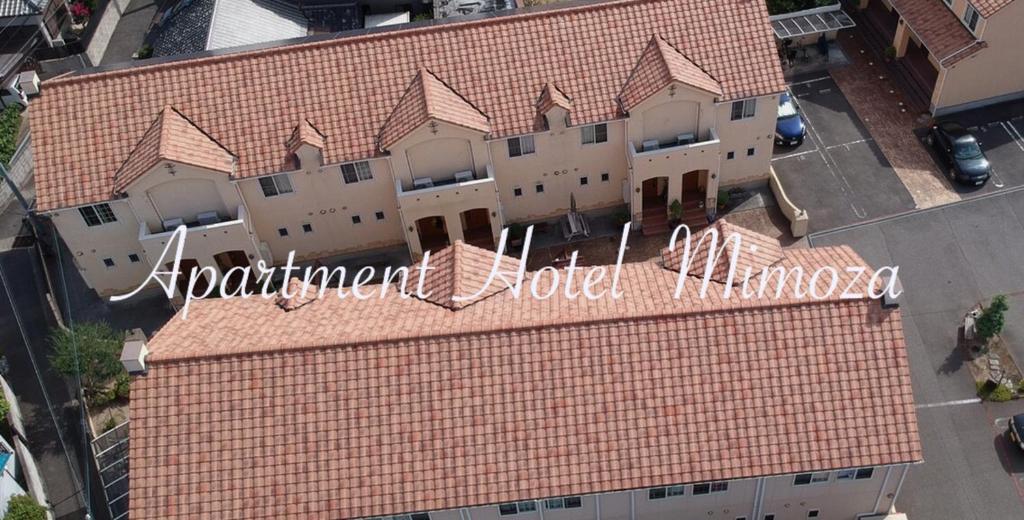 洲本市アパートメントホテル Mimoza的建筑物的顶部景观,上面有标志