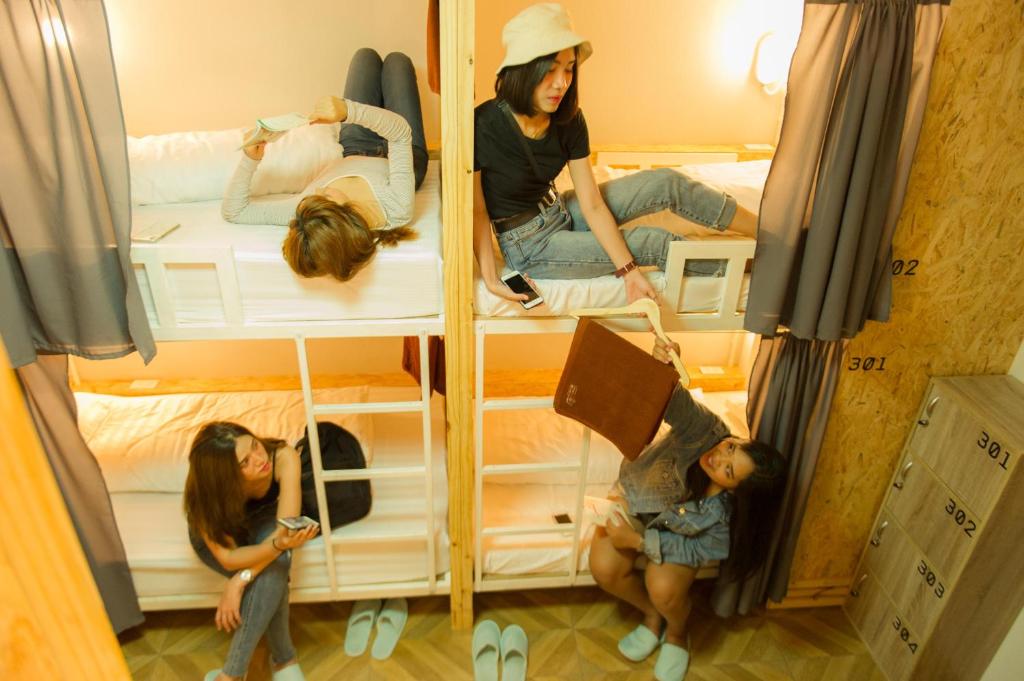 合艾Khoksametchun Hostel的三个女孩坐在双层床上