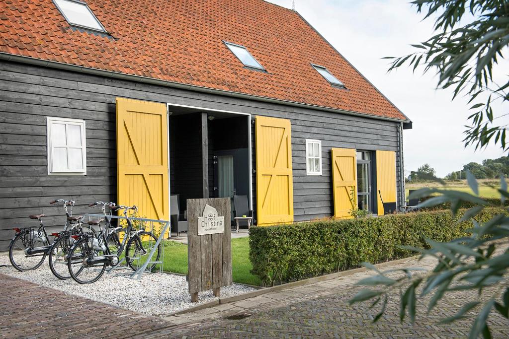 弗劳温普尔德霍夫克里斯蒂娜乌弗酒店的一座设有黄色门和自行车停放在外的建筑