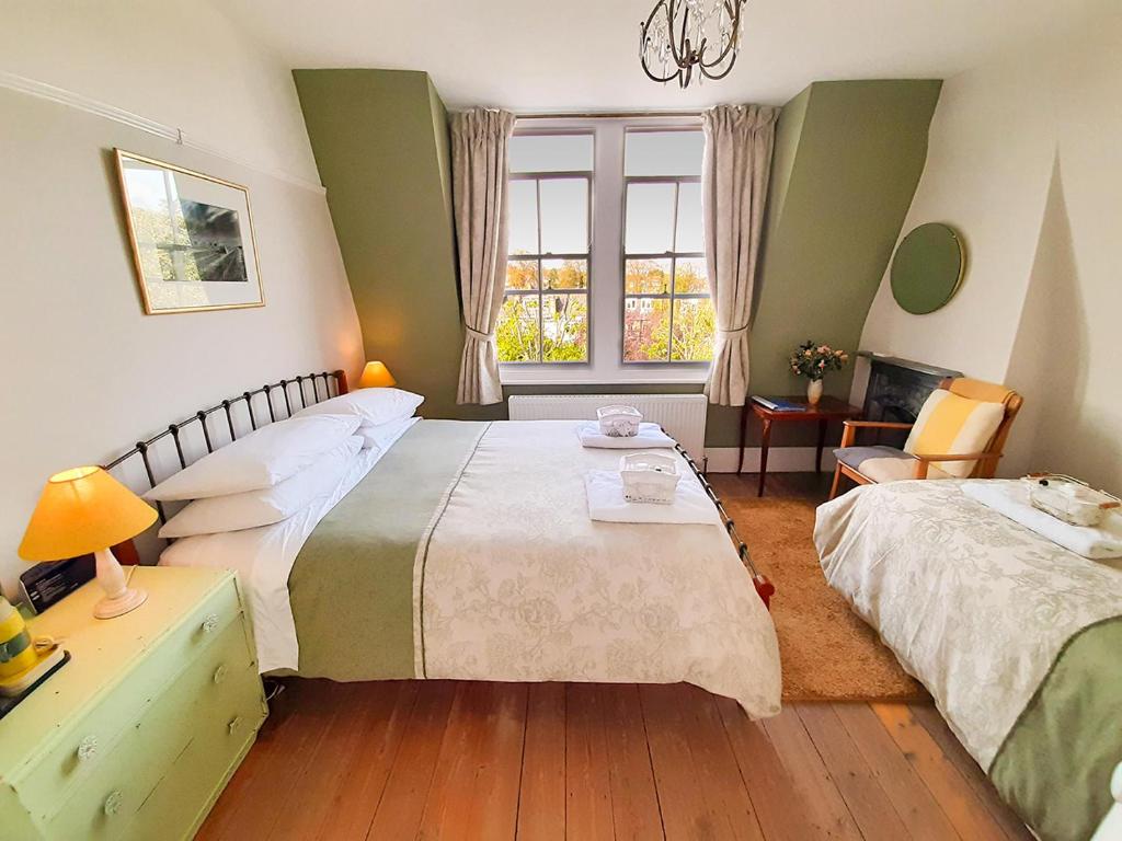 伦敦麦斯威山住宿加早餐旅馆的一间卧室配有两张床、一张桌子和一把椅子