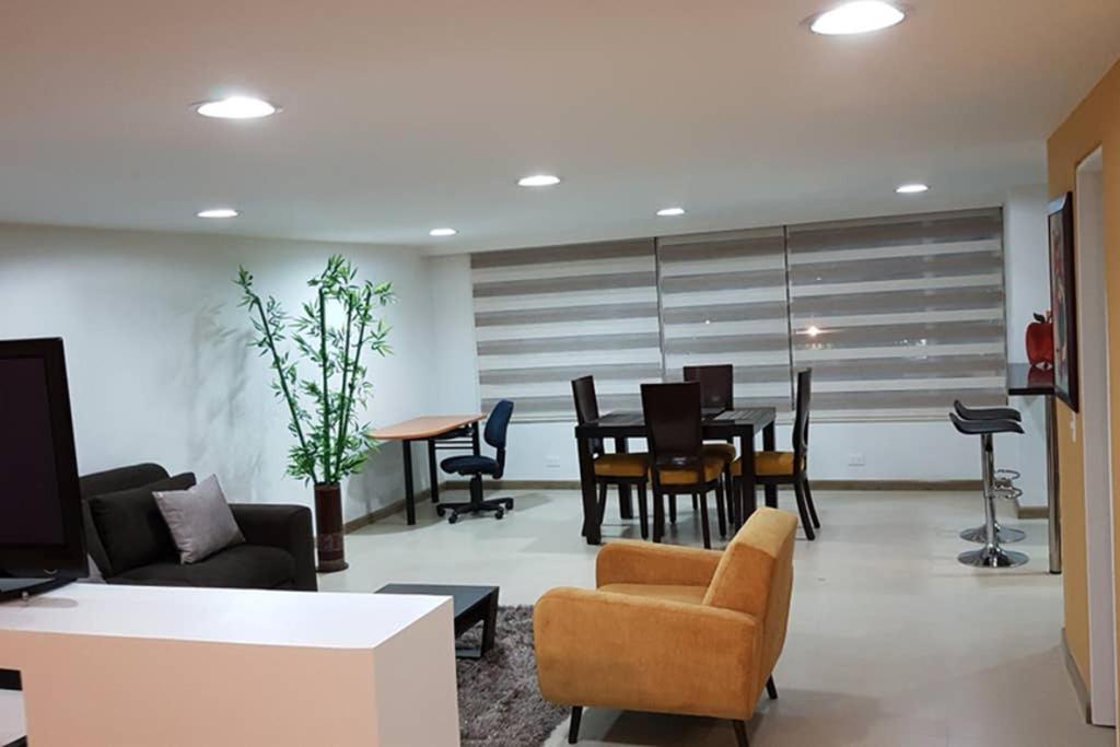 波哥大Apartamento Parque Virrey的客厅配有沙发和桌椅