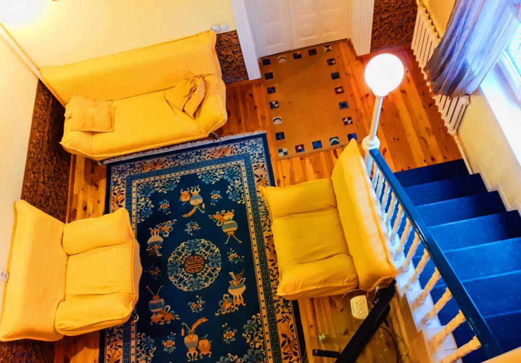 比什凯克Хостел Особнячок的楼梯,有黄色的椅子,蓝色的地毯