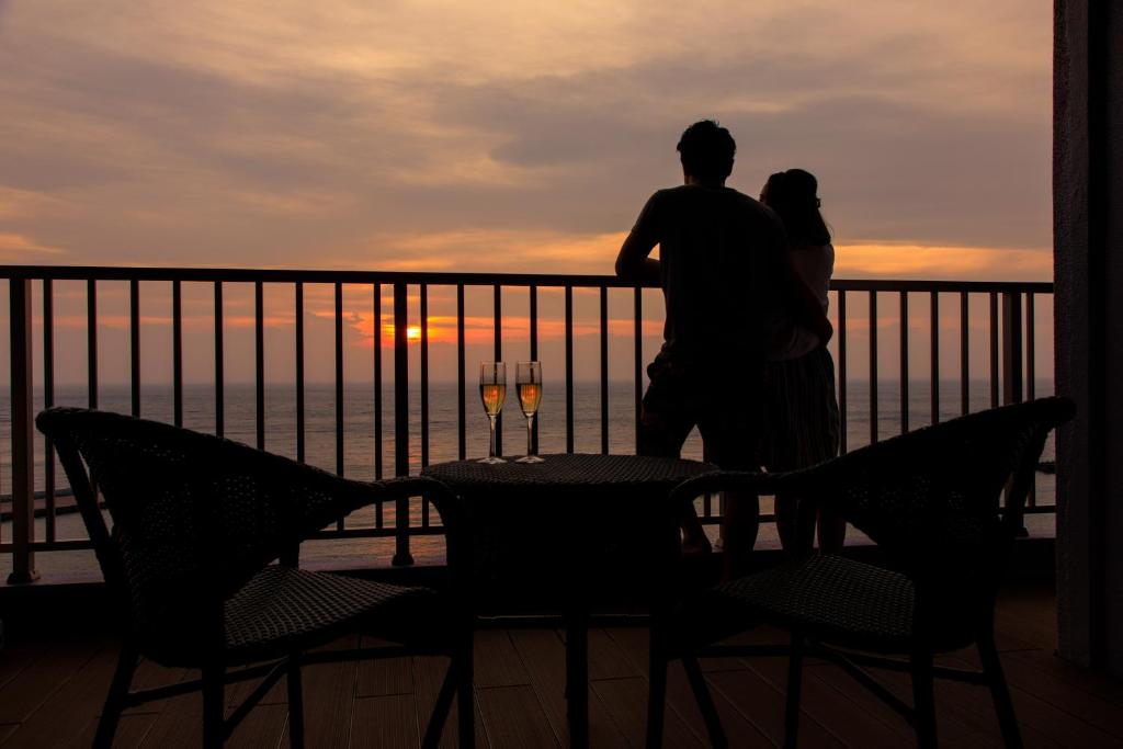 伊豆明治馆碧风日式旅馆的一对夫妇站在阳台上欣赏日落美景