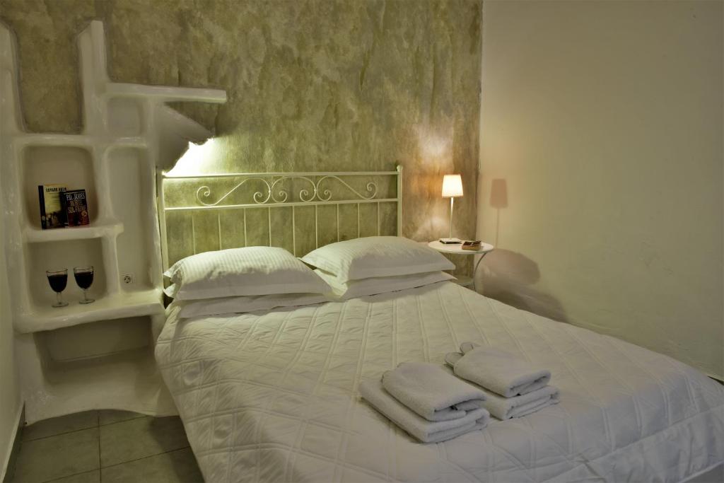 阿达玛斯Adamas Hotel的卧室配有白色床和毛巾