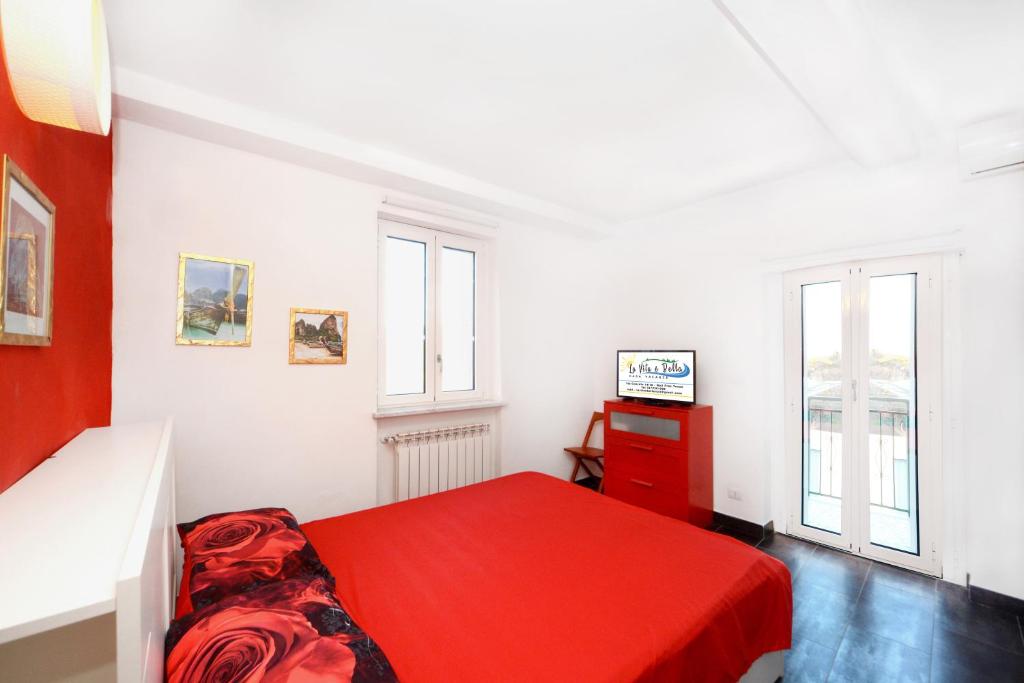 诺利La vita è bella - Noli的一间白色卧室,配有红色的床和电视