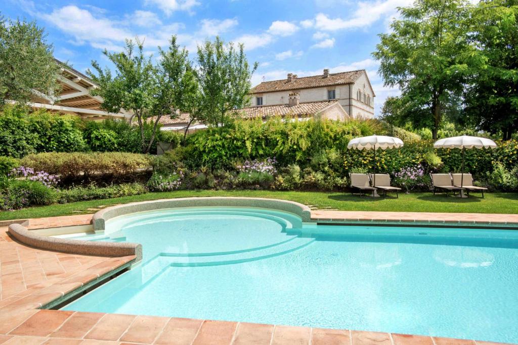 锡罗洛Il Casale Di Giulia的一座带房子的庭院内的游泳池