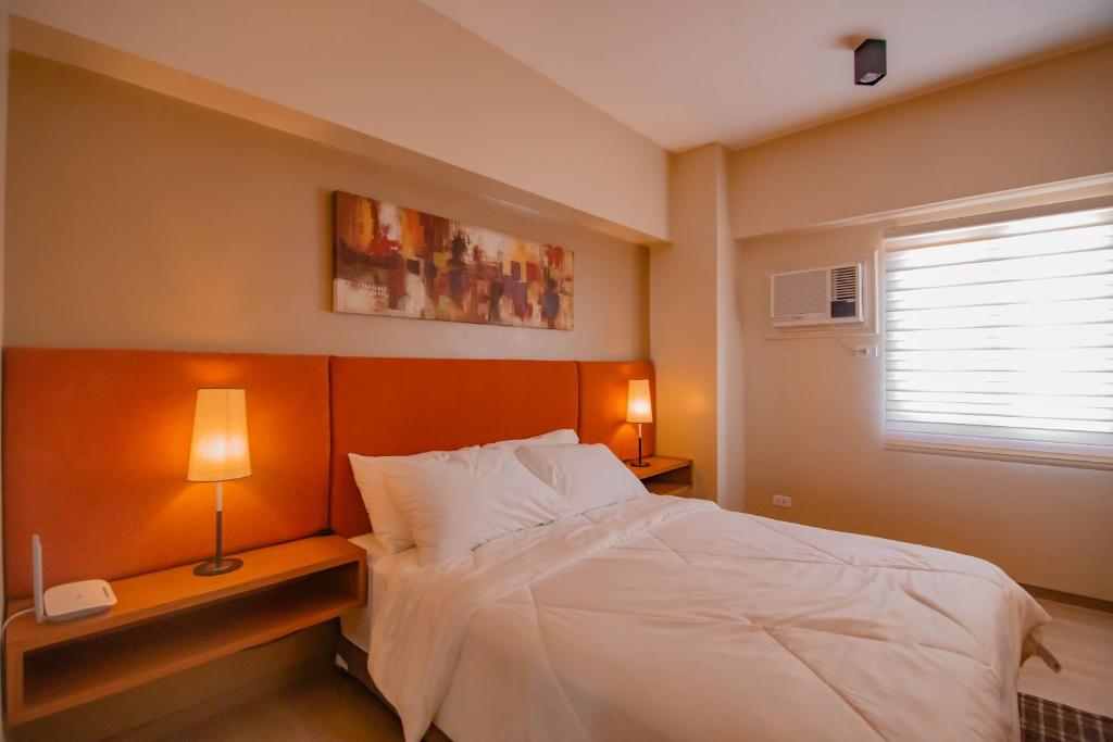 宿务MIGAs Haven at Sunvida Tower across SM City的卧室配有白色的床和窗户。