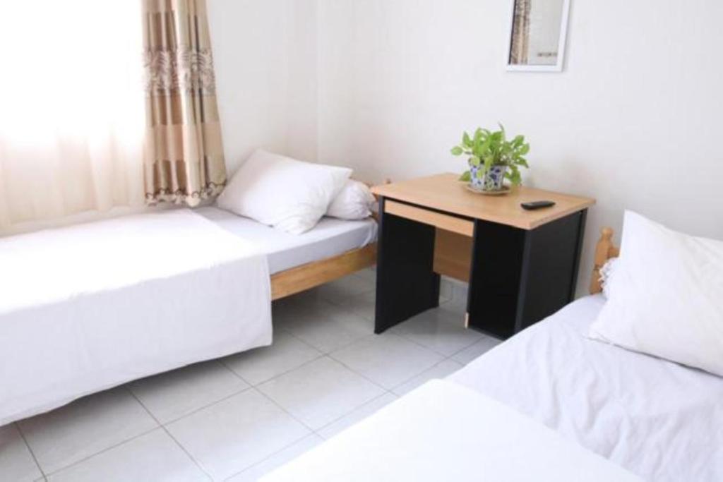 巴东Rumah Kita的客房设有两张床和一张木桌。