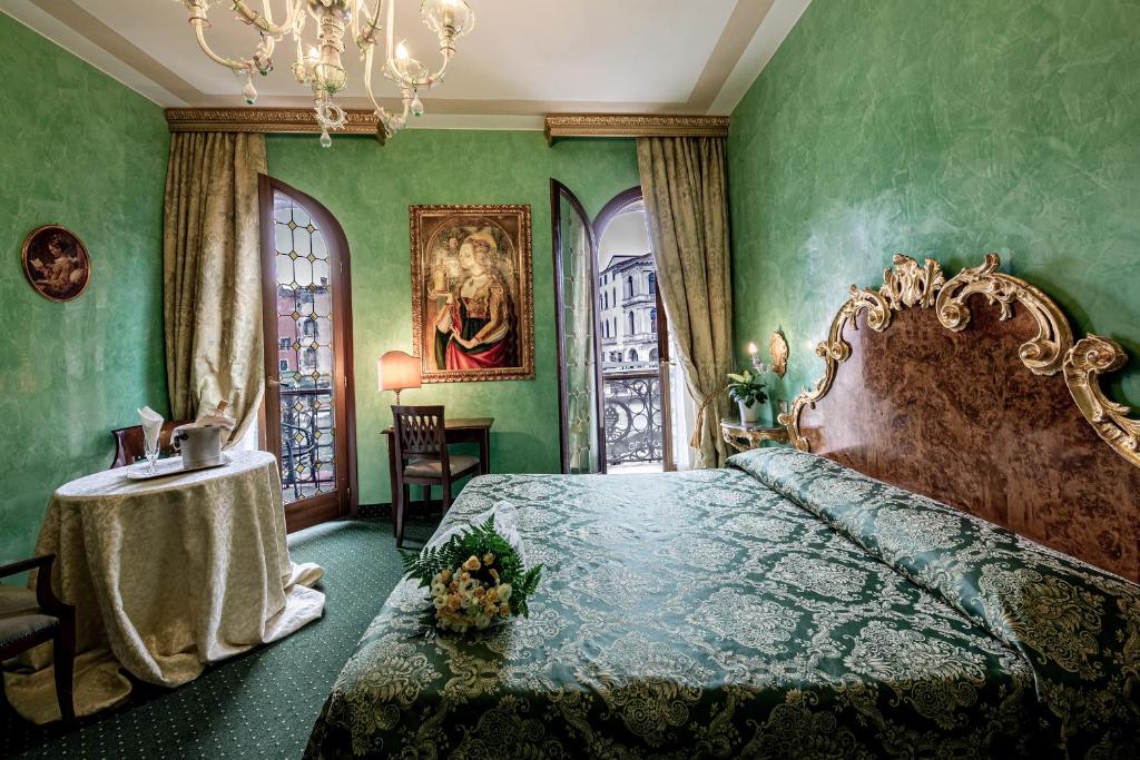 威尼斯马可尼酒店的一间卧室配有一张床和一张桌子