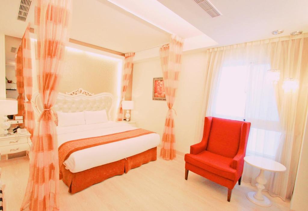 台东中华典藏商旅的一间卧室配有一张床和一张红色椅子