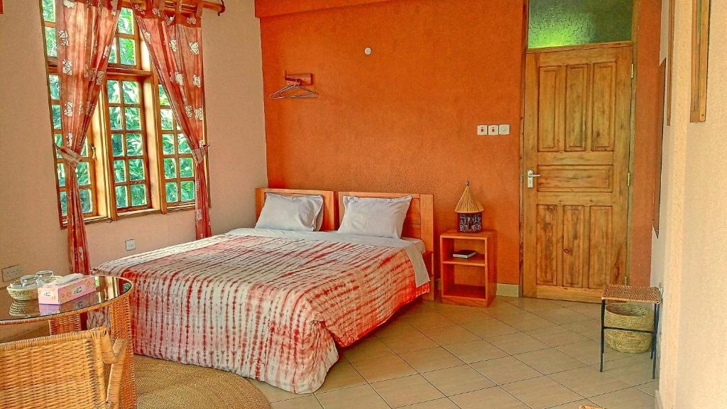 育空河Kilimanjaro Eco Lodge的一间卧室配有一张橙色墙壁的床