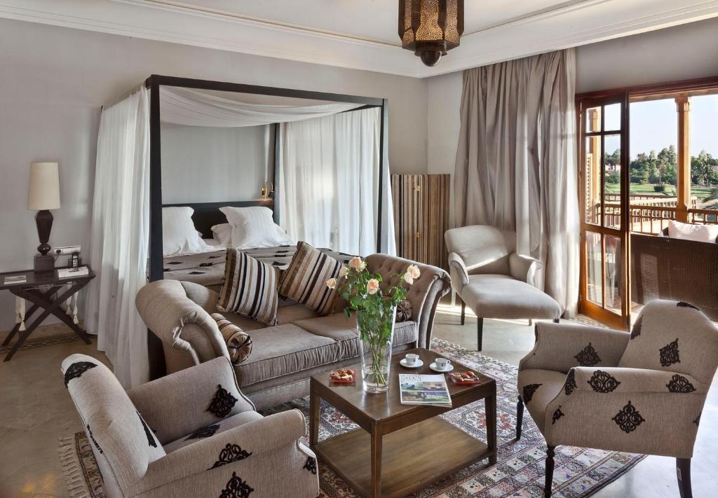 马拉喀什Golf Club Rotana Palmeraie的客厅配有沙发、椅子和1张床
