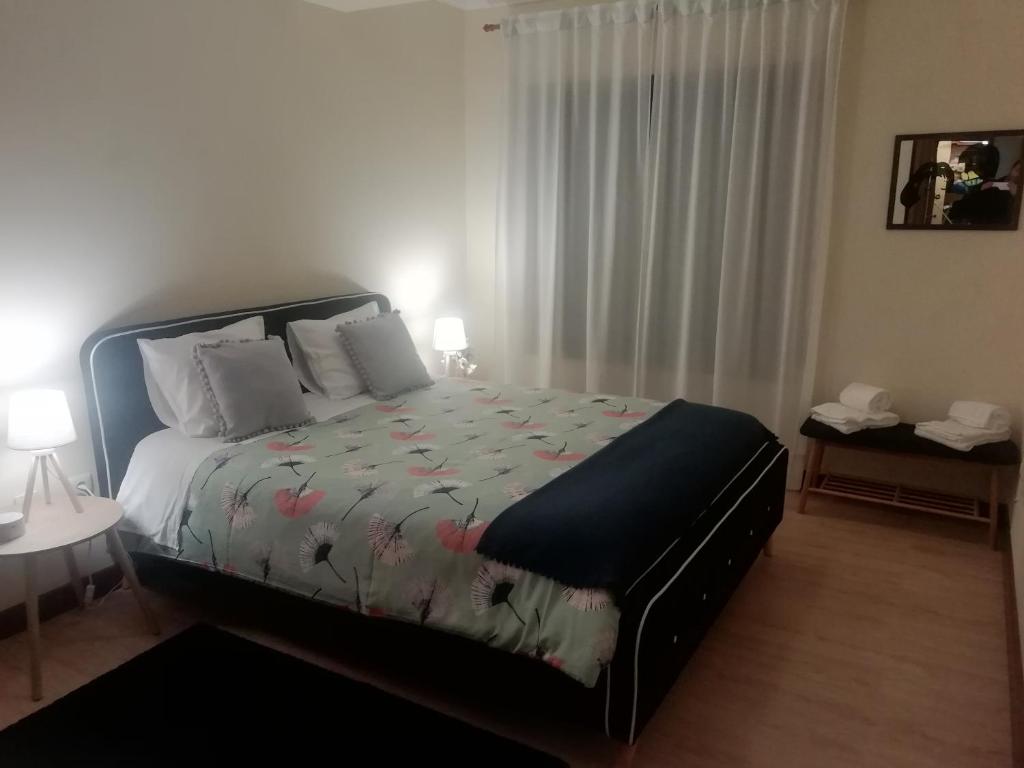 阿威罗Sailorman House的一间卧室配有一张带花卉棉被的床