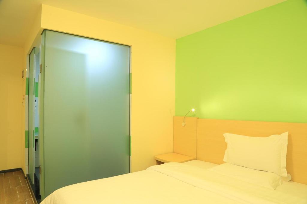 贵阳7Days Inn Guiyang Ergezhai的一间卧室设有一张床和一个滑动玻璃门