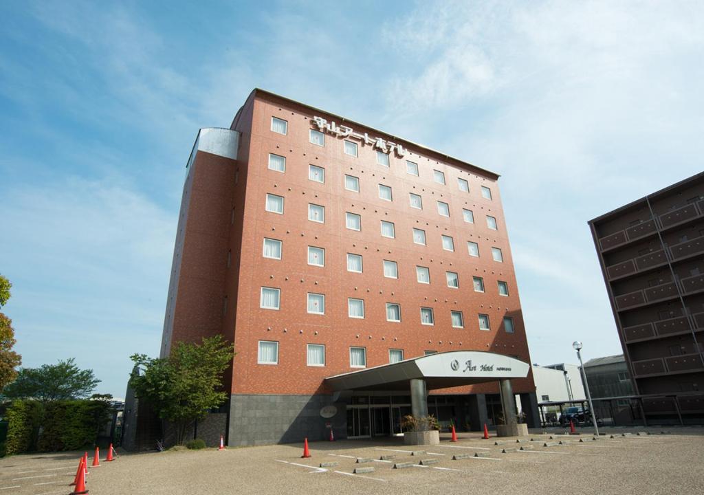 守山Moriyama Art Hotel的酒店大楼前面有橙色锥形