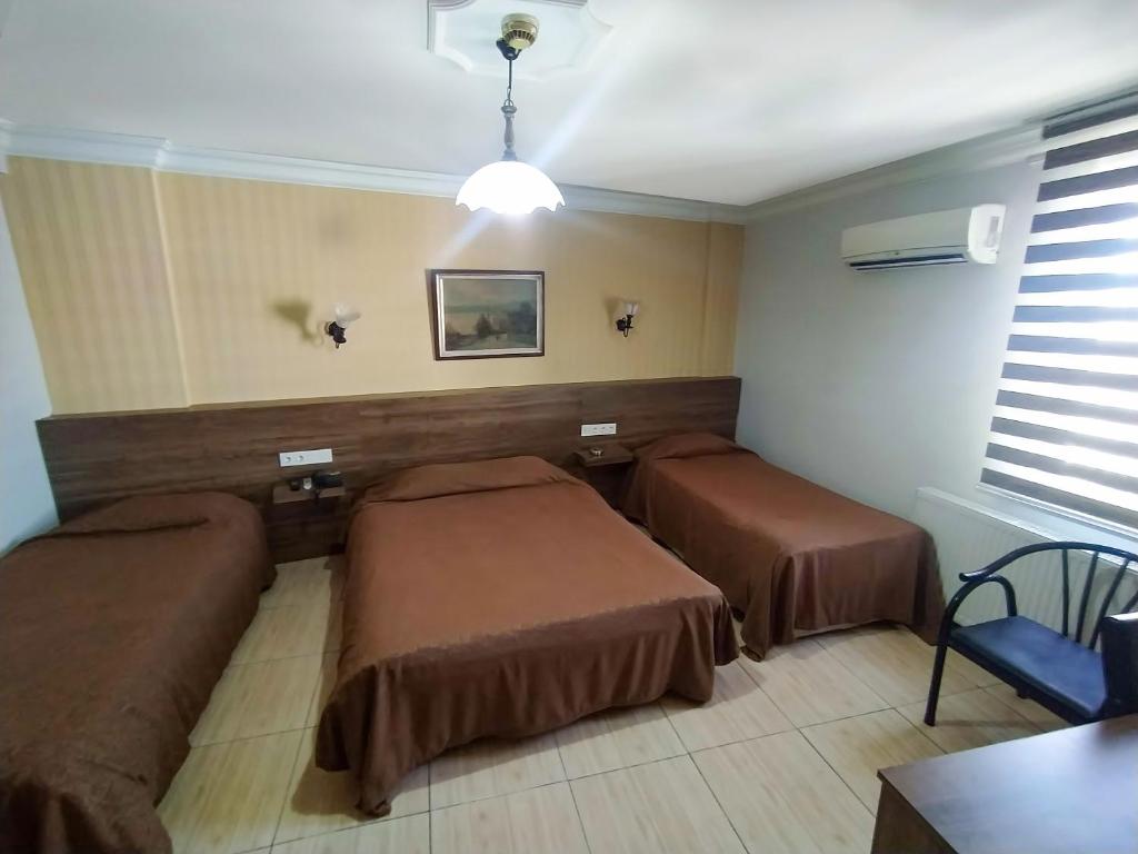 加济安泰普尤努斯酒店的一间设有两张床和一张桌子的房间