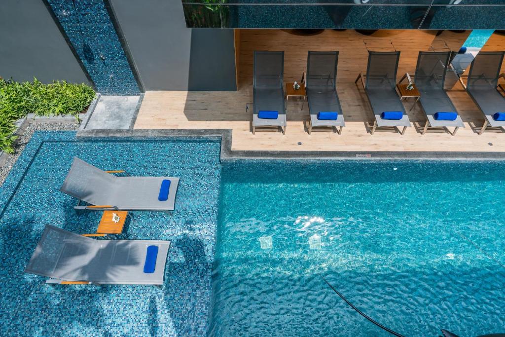 华欣Maven Stylish Hotel Hua Hin的享有带椅子的游泳池和游泳池的顶部景致