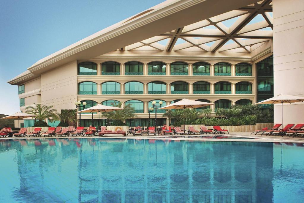 迪拜Mövenpick Grand Al Bustan的酒店前的游泳池