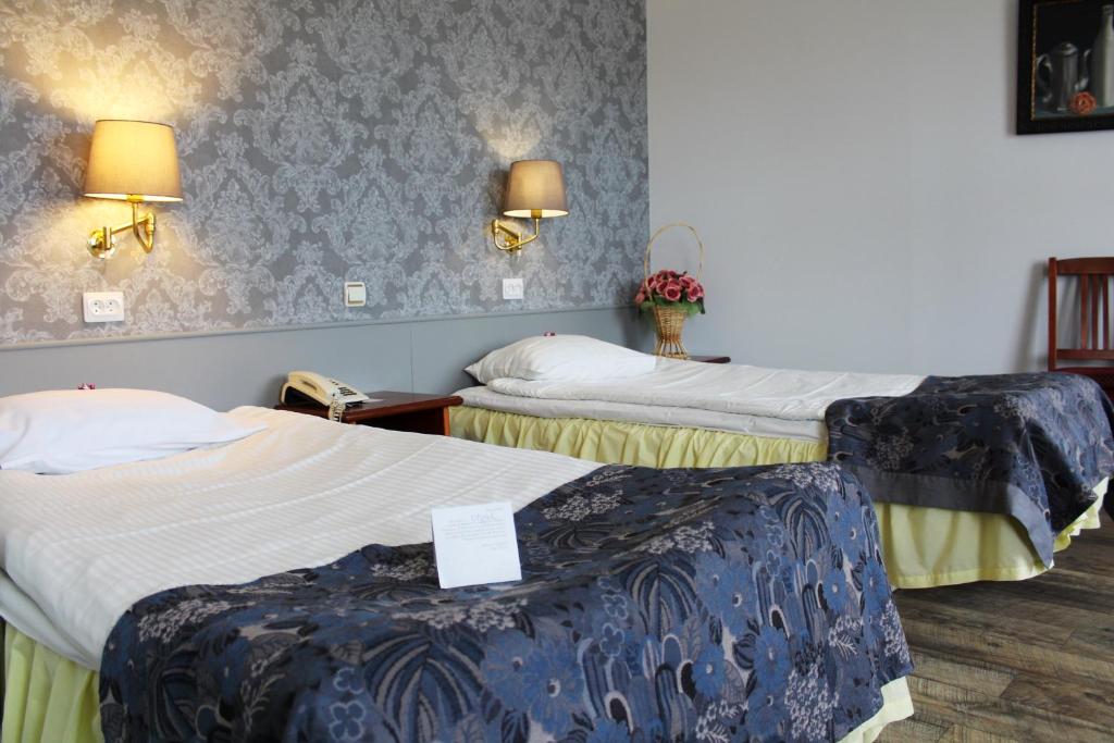 里加NB Hotel with Free Parking的酒店客房设有两张床和两盏灯。