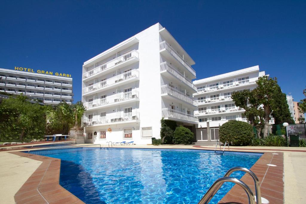 罗列特海岸加尔比别墅酒店的大楼前设有游泳池的酒店