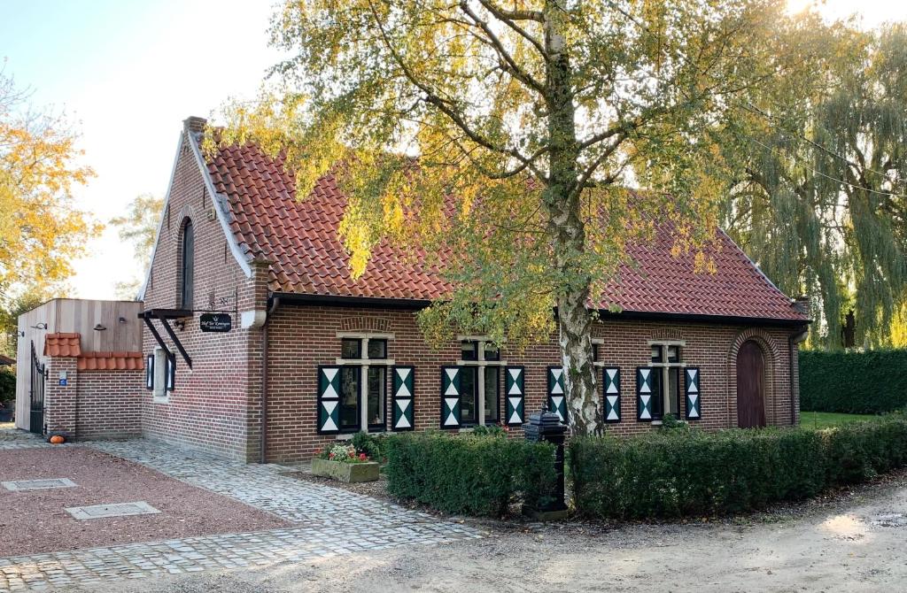 阿尔斯特B&B Hof Ter Koningen的前面有树的砖房