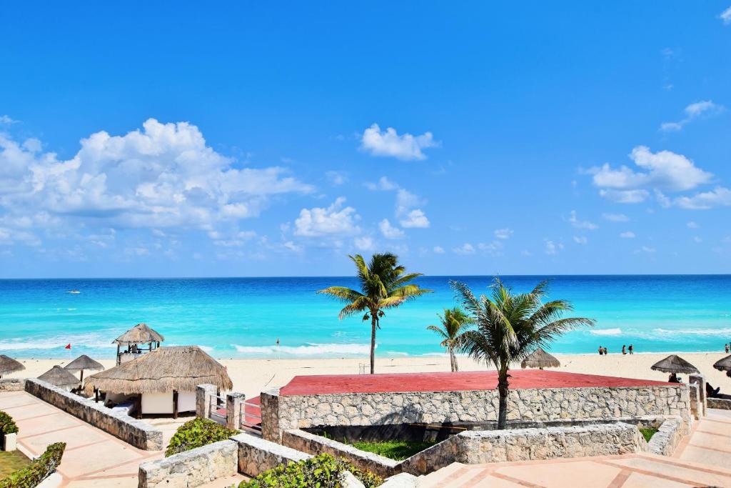 坎昆Solymar Condo Beach Resort by Casago的享有棕榈树海滩和大海的景色