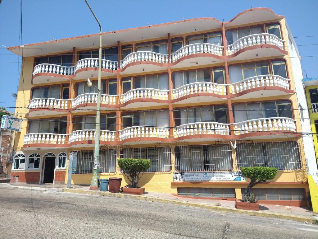 阿卡普尔科Hotel Olimar的一座橙色的建筑,在街上设有白色阳台