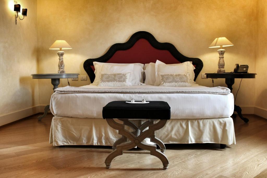法诺瑟瑞酒店的一间卧室配有一张大床和两张桌子