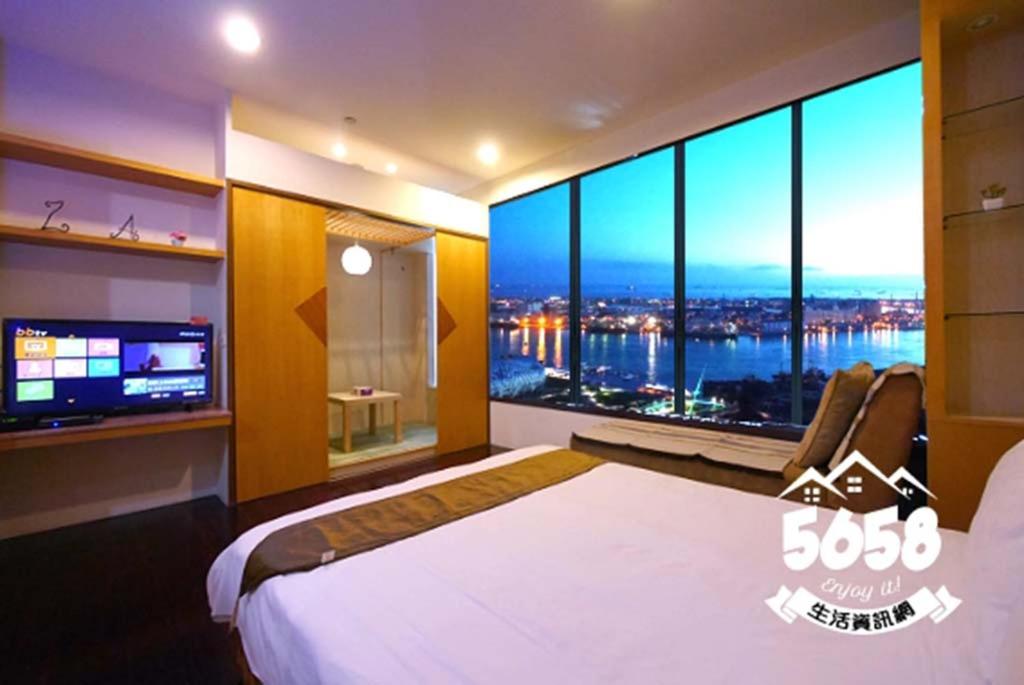 高雄85假期会馆的一间卧室设有一张大床和一个大窗户