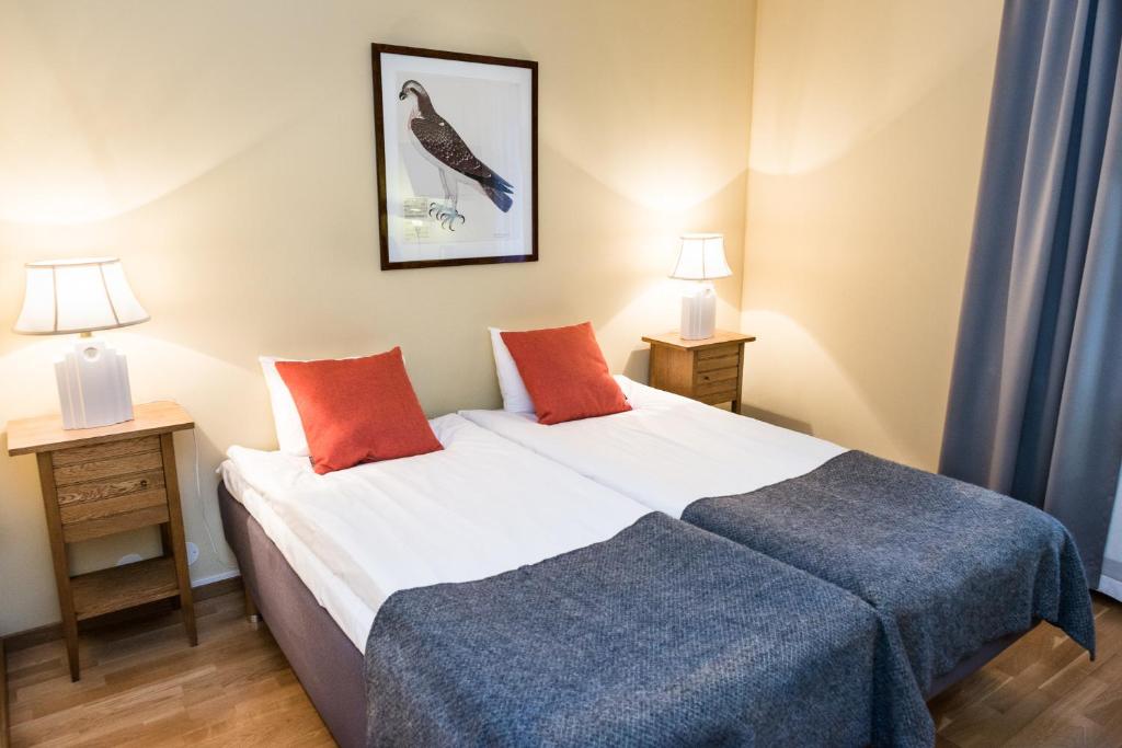 Stranderäng诺登斯阿克酒店的一间卧室配有一张带2个床头柜和2盏灯的床。