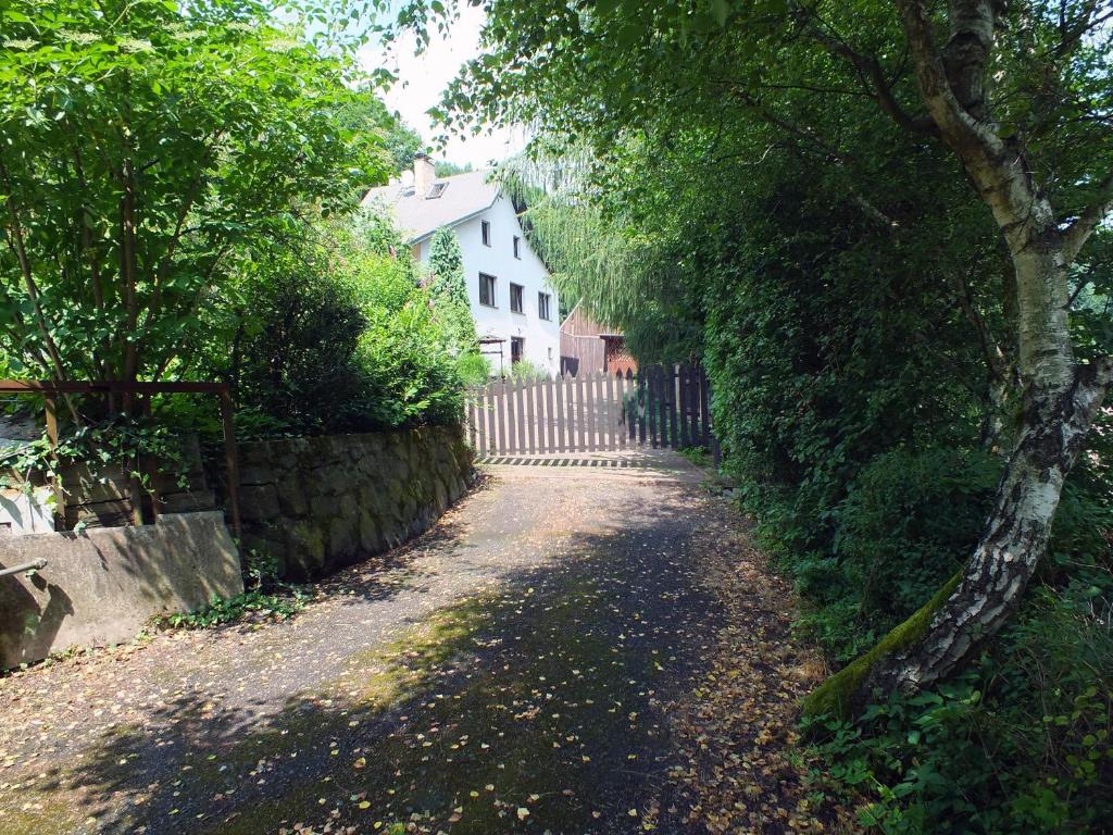 PerštejnChata Údolíčko的一条土路,有栅栏和白色的房子