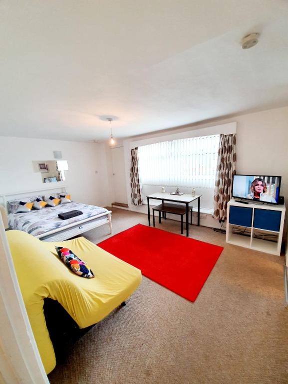 雷利Rayleigh Town Centre 2 Bedroom Apartment的一间卧室配有黄色的床和红色地毯
