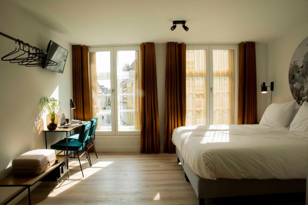登博斯Hotel Haverkist的一间卧室配有一张床、一张书桌和一个窗户。
